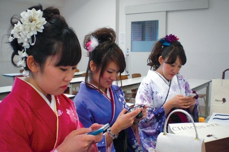 Japanese women using smartphones and a camera