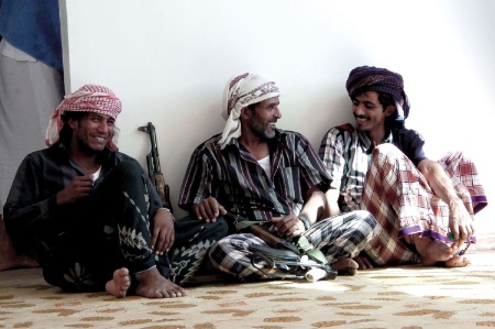 Armed Mahri tribesmen sitting and chatting