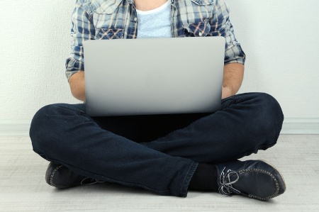 Seated man working on laptop