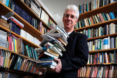 Thomas Docherty holding pile of books