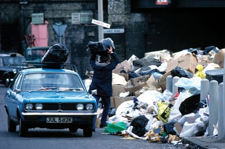 Man throwing rubbish bag onto a pile
