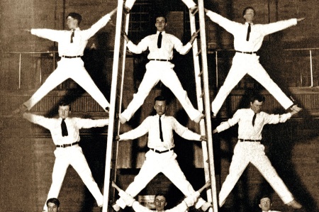 Men balancing in a pyramid formation