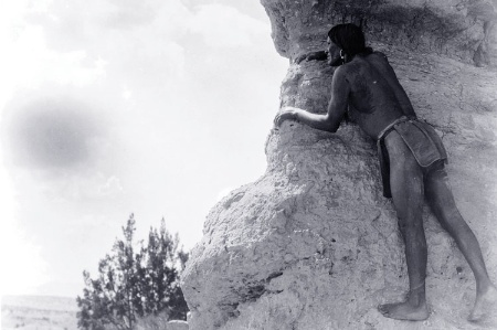 Native American man climbing rocks