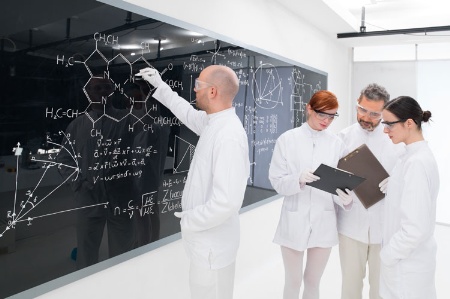 Four scientists working by blackboard