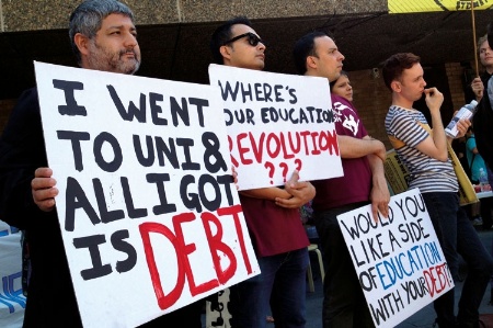 Demonstrators holding student debt signs