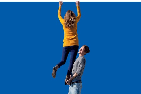 Man boosting woman to top of wall