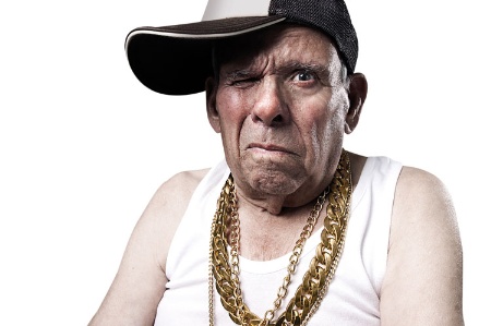 Old man wearing baseball cap and gold chains