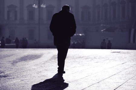 Man walking on pavement at dusk