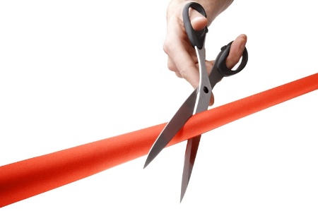 Scissors cutting red tape