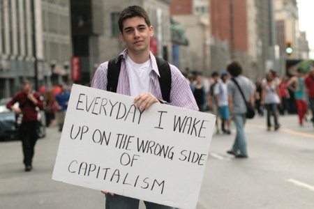 Anti-capitalism demonstrator holding sign