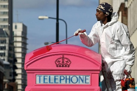 Man painting London phonebox