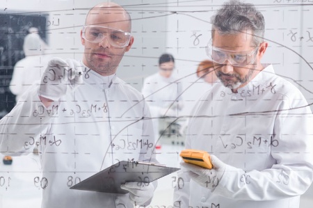 Two scientists writing formulae